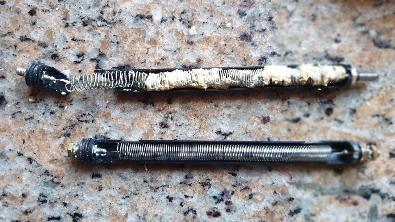 Instantaneous heater coil heavily encrusted with limescale after six months of untreated water, shown above an identical new coil