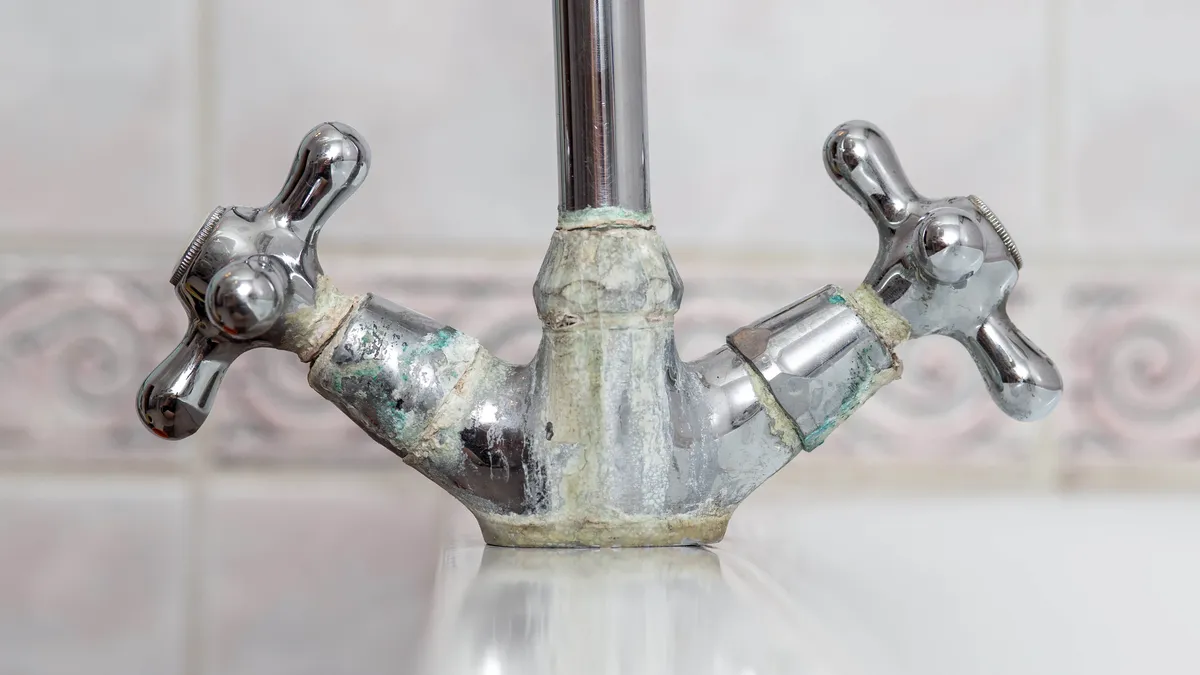 Faucet heavily coated with limescale and mineral deposits