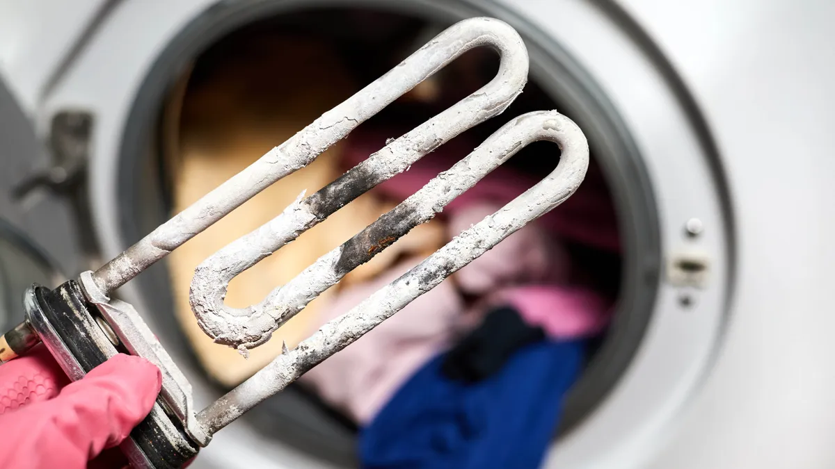 Washing machine heating element encrusted with hard-water scale